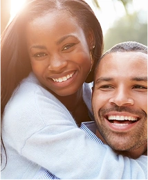 A happy couple hugging, smiling at the camera