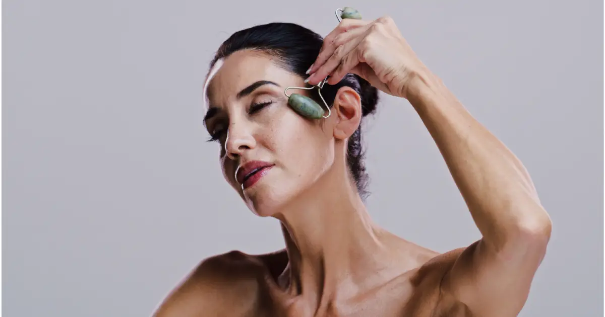 A woman gently massaging her face with a lymphatic roller in Temecula CA